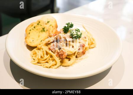 spaghetti con pancetta, spaghetti alla carbonara o pasta alla carbonara e pane all'aglio Foto Stock