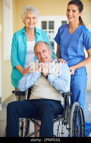 Sostenere i suoi pazienti durante gli anni più anziani. un medico in piedi con la paziente anziana e la moglie. Foto Stock