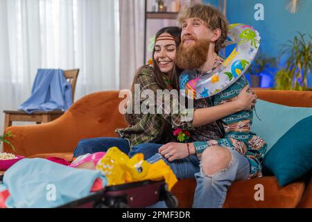 Famiglia matrimonio coppia uomo donna turisti imballaggio sacco di cose in valigia bagagli, preparazione per viaggio vacanza viaggio in mare. Marito moglie insieme preparandosi per la strada, facendo piani di viaggio Foto Stock