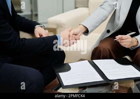 Primo piano dei giovani imprenditori che scuotono le mani per concludere un accordo durante la riunione in carica Foto Stock