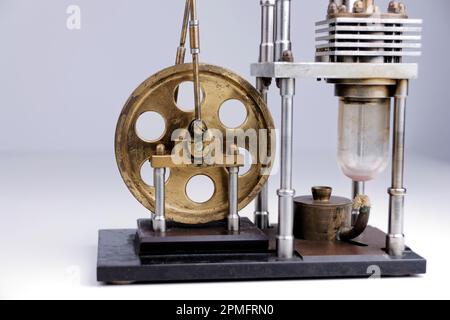 primo piano della costruzione di un motore stirling con tavolo bianco e sfondo bianco Foto Stock