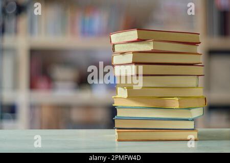 Stack di libri con sfondo sfocato libreria, lettura, apprendimento, istruzione home Office concetto Foto Stock
