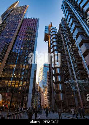 I lavoratori si trovano a casa nel quartiere finanziario di Londra. La testa torreggiante sono gli iconici Lloyds 'Inside out' di Londra, lo Scalpel e la Walkie Talkie Foto Stock