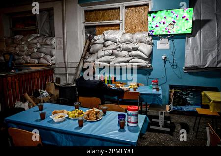 ORIKHIV, UCRAINA - 12 APRILE 2023 - Un uomo guarda la TV in un punto di invincibilità, Orikhiv, Zaporizhzhzhia Regione, sud-est Ucraina. Foto Stock