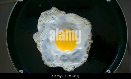 Lato soleggiato su uovo in camicia o omelette su una padella o padella. Vista dall'alto. Foto Stock