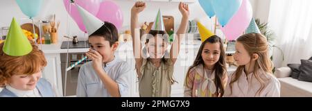 gruppo e bambini felici in berretti divertirsi durante la festa di compleanno a casa, banner, immagine stock Foto Stock