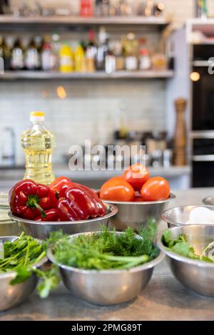 Le verdure fresche si trovano in una ciotola di metallo: Pomodori, asparagi, cetrioli, verde. Le verdure fresche si trovano in una ciotola di metallo: Pomodori, asparagi, cetrioli Foto Stock