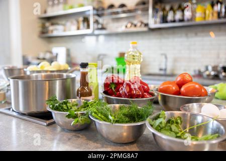 Le verdure fresche si trovano in una ciotola di metallo: Pomodori, asparagi, cetrioli, verde. Le verdure fresche si trovano in una ciotola di metallo: Pomodori, asparagi, cetrioli Foto Stock