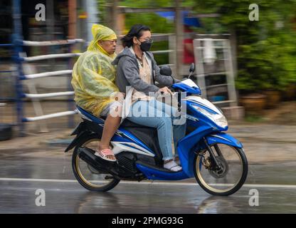 SAMUT PRAKAN, THAILANDIA, 21 2022 SETTEMBRE, due donne guidano moto sotto la pioggia Foto Stock