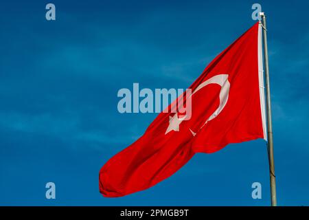 Bandiera turca. Bandiera ondulata di Turkiye su sfondo cielo blu. Festività nazionali della Turchia. Foto Stock