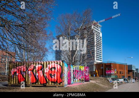 Graffiti ha coperto i contenitori di trasporto davanti, Kalasatama alti edifici sullo sfondo, nel distretto di Suvilahti di Helsinki, Finlandia Foto Stock