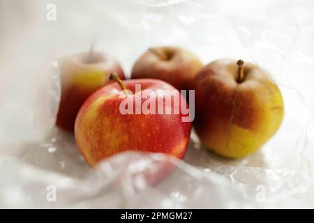 Immagine simbolica sul tema della nutrizione e dei rifiuti di imballaggio. Le mele sono in un sacchetto di plastica. Berlino, 13 aprile 2023. Foto Stock