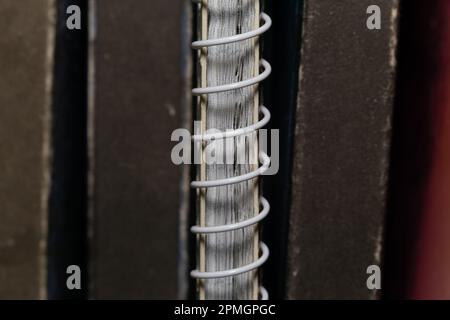 Un notebook caricato a molla tra i vecchi volumi di libri marroni, vista macro in primo piano Foto Stock