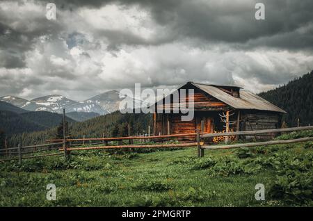 Una vecchia casa colonica in un prato di montagna sopra i Carpazi. Bellissimo paesaggio a piedi in Ucraina. Foto Stock