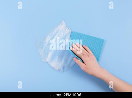Donna che tiene la spugna di lavaggio mano e detersivo suta Foto Stock