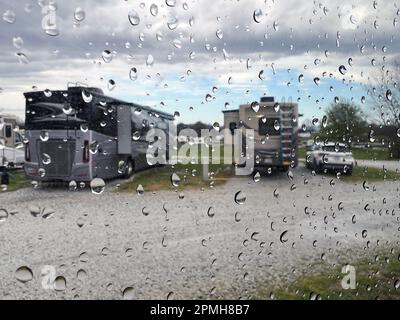 Una giornata di pioggia al campeggio, con vista sui veicoli ricreativi di lusso. Foto Stock