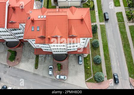 vista aerea di case residenziali con tetti rossi, alberi verdi su prato e auto parcheggiate. paesaggio urbano. Foto Stock