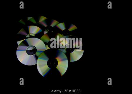 CD e DVD isolati su sfondo nero con riflessi colorati Foto Stock
