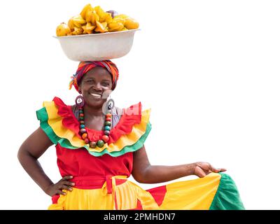 Buon venditore di frutta fresca di strada, Palenquera, isolato su sfondo bianco. Allegra donna afro-colombiana in costumi tradizionali, Cartagena, Colombia. Foto Stock
