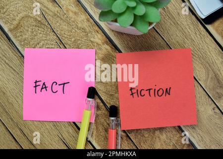 Concetto di fatto o di opinione scrivere su note appiccicose isolate su Tavola di legno. Foto Stock