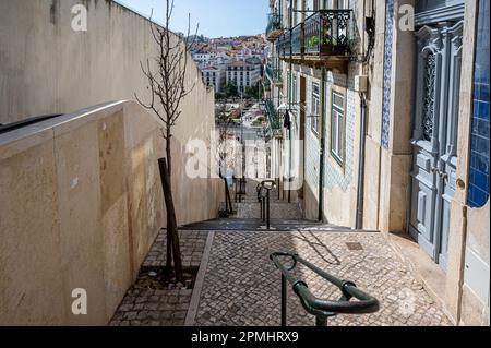 Strada stretta con scale e scala mobile a Lisbona, Portogallo Foto Stock