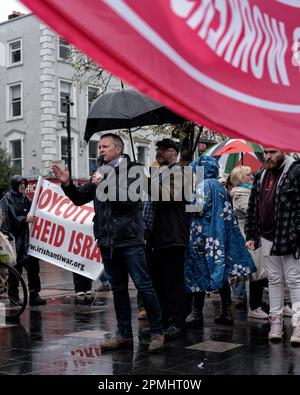 Dublino, Irlanda. 12th Apr, 2023. Richard Boyd Barrett da persone prima del profitto parla attraverso un microfono durante la dimostrazione. I manifestanti si sono riuniti per opporsi alla visita di Biden in Irlanda, nel centro di Dublino, dove hanno partecipato numerose organizzazioni e gruppi di sostegno, tra cui persone prima del profitto, la Campagna di solidarietà Irlanda-Palestina, il movimento anti-guerra irlandese, il Partito comunista d'Irlanda e il movimento Connolly Youth, tra gli altri. La protesta ha visto la presenza di alcuni oratori, uno dei quali è stato Richard Boyd Barrett, proveniente da persone prima del profitto. Credit: SOPA Images Limited/Alamy Live News Foto Stock