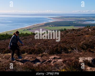 Donna che cammina fino a ben Bhraggie, Sutherland Foto Stock