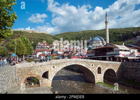 Vecchio ponte in pietra sul fiume Bistrica, Balcani, ottomano, ponte ad arco in pietra, Moschea Sinan Pasha, Fortezza sulla sinistra, Prizren, Repubblica del Kosovo Foto Stock