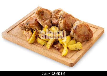 Cosce di pollo arrosto con patate a fette al forno su tagliere di legno isolato su bianco con percorso di taglio Foto Stock