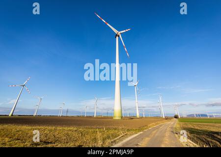 Una vista panoramica delle turbine eoliche che ruotano in un paesaggio rurale, fornendo energia pulita all'area circostante Foto Stock