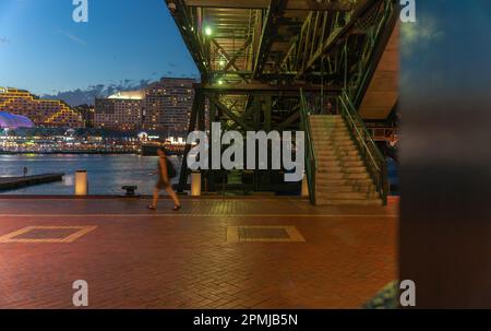 Sydney Australia - Gennaio 25 2011; Notte sulla strada, vista da Under Pyrmont Bridge con donna sfocata in movimento Foto Stock