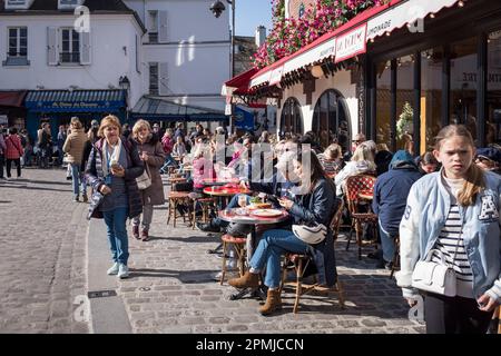 Turisti e locali sulla terrazza di un caffè al sole di primavera, a Montmartre, a Parigi, Francia Foto Stock