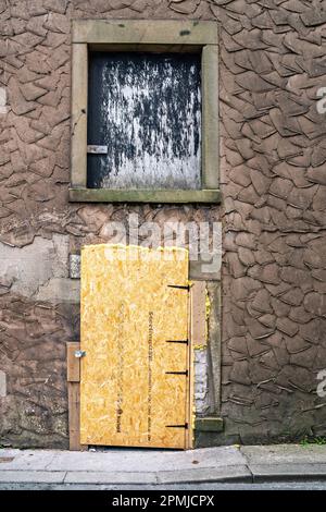 La porta e la finestra dell'edificio commerciale sono salite a bordo Foto Stock