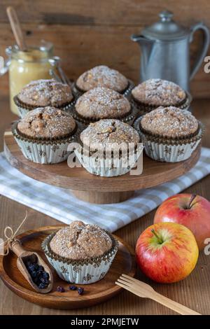 muffin alle mele vegane con ribes zante su un piatto di legno Foto Stock