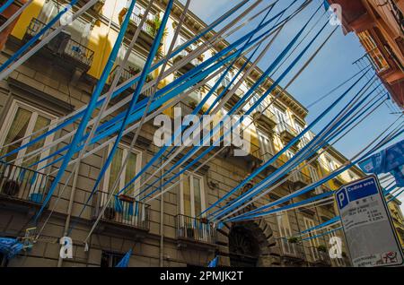 Ammira il bunting blu e bianco, le bandiere e gli streamers nel centro storico di Napoli mentre i residenti celebrano il successo della S.S.C. Foto Stock