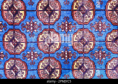 Colorato tappeto di seta fatto a mano con motivi in tonalità rosse, tradizionale stile uzbekistan. Primo piano. Foto Stock