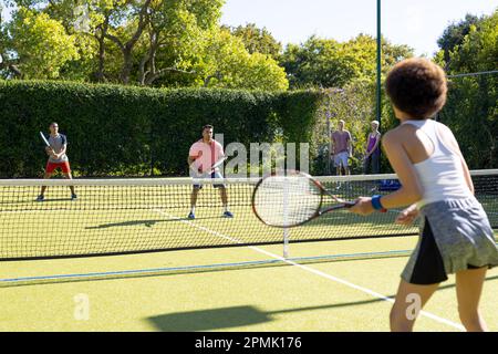 Felice gruppo di amici che giocano a tennis presso il campo da tennis Foto Stock