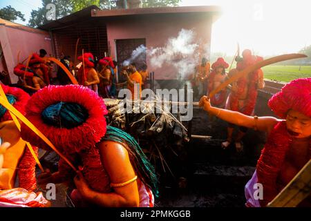 Bangladesh, 13/04/2023, con la fine del mese di Chaitra, l'ultimo dell'anno di Bangla, la comunità indù si riunisce in un festival dedicato al culto di Lord Shiva e Parvati. Il programma è localmente noto come "Lal Kach" (vetro rosso). L'idea centrale di questo programma è che un gruppo di soldati guidati da Shiva appaia sulla terra con una missione: Allontanare le forze del male. Questi soldati, che risplendono nella luce divina di Shiva, marciano verso i templi vicini. Tutto fa parte di una lunga tradizione che risale a centinaia di anni fa. Gli Indù, specialmente i giovani, si dipingono in r Foto Stock