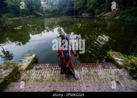 Bangladesh, 13/04/2023, con la fine del mese di Chaitra, l'ultimo dell'anno di Bangla, la comunità indù si riunisce in un festival dedicato al culto di Lord Shiva e Parvati. Il programma è localmente noto come "Lal Kach" (vetro rosso). L'idea centrale di questo programma è che un gruppo di soldati guidati da Shiva appaia sulla terra con una missione: Allontanare le forze del male. Questi soldati, che risplendono nella luce divina di Shiva, marciano verso i templi vicini. Tutto fa parte di una lunga tradizione che risale a centinaia di anni fa. Gli Indù, specialmente i giovani, si dipingono in r Foto Stock