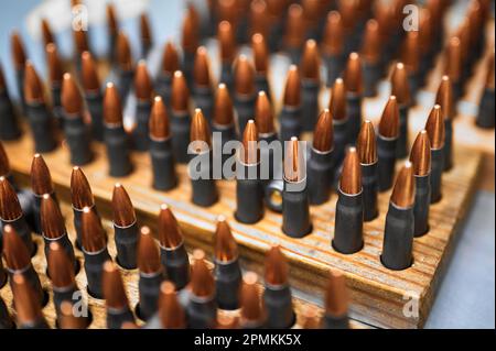 Pallottole di riffle in scaffali di legno in officina di stabilimento di produzione Foto Stock