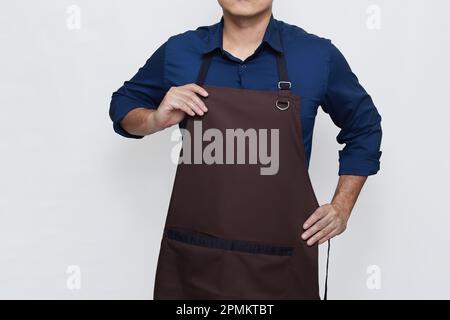 Uomo asiatico indossa grembiule in abbigliamento casual elegante, in piedi posa mentre indossa e riponi il grembiule, senza volto isolato sfondo bianco Foto Stock