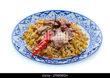 Delizioso pilaf festivo uzbeko in un piatto su uno sfondo bianco isolato Foto Stock