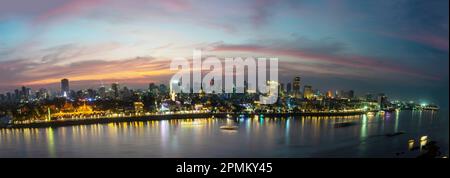 Il bagliore dorato sopra la capitale della Cambogia, è affollato Riverside e famosi monumenti e il Palazzo reale, mentre il sole tramonta da dietro Foto Stock