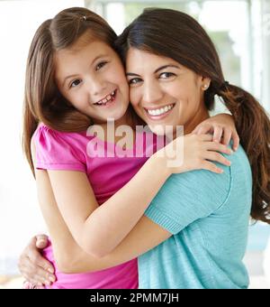 Abbracciando affettuosamente. Ritratto di una bella giovane madre che trascorre il tempo con la sua figlia carina. Foto Stock
