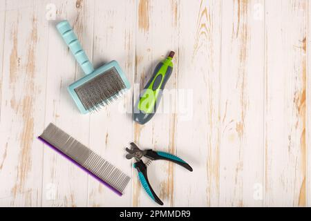 Set di strumenti per la cura del corpo: Regolacapelli elettrico, forbici per la cura del corpo, spazzola in lana e forbici per la cura del corpo. Sfondo con spazio di copia su tema di cura di animali domestici, Foto Stock