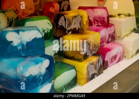 Sapone aromatico fatto a mano. Messa a fuoco selettiva. Saponi e cosmetici fatti a mano in Street market festival. Saponette artigianali al banco del negozio tradizionale. Piramide di sapone fatto a mano con additivi ed estratti naturali. Foto Stock