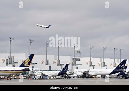 La porta. 12th Apr, 2023. Impressioni dall'aeroporto Franz Josef Strauss di Monaco il 12 aprile 2023. L'aereo di Lufthansa decolora, partendo sopra il Terminal 2 con l'aereo parcheggiato al cancello. ? Credit: dpa/Alamy Live News Foto Stock