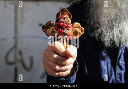 Gerusalemme est, Israele. 14th Apr, 2023. Un cristiano ortodosso porta una croce di legno lungo la Via dolorosa nella Città Vecchia di Gerusalemme durante la processione del Venerdì Santo ortodosso prima del Sabato Santo di domani. I pellegrini cristiani hanno partecipato alle processioni lungo il cammino, mentre, secondo la tradizione, Gesù Cristo ha portato la croce il suo ultimo giorno prima della crocifissione. Credit: SOPA Images Limited/Alamy Live News Foto Stock