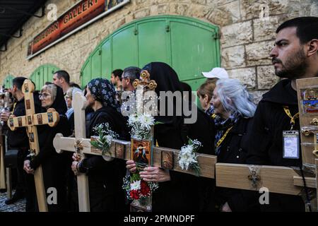 Gerusalemme est, Israele. 14th Apr, 2023. I cristiani ortodossi portano croci di legno lungo la Via dolorosa nella Città Vecchia di Gerusalemme durante la processione del Venerdì Santo ortodosso prima del Sabato Santo di domani. I pellegrini cristiani hanno partecipato alle processioni lungo il cammino, mentre, secondo la tradizione, Gesù Cristo ha portato la croce il suo ultimo giorno prima della crocifissione. Credit: SOPA Images Limited/Alamy Live News Foto Stock