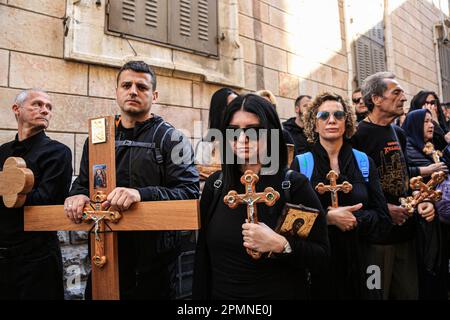 Gerusalemme est, Israele. 14th Apr, 2023. I cristiani ortodossi portano croci di legno lungo la Via dolorosa nella Città Vecchia di Gerusalemme durante la processione del Venerdì Santo ortodosso prima del Sabato Santo di domani. I pellegrini cristiani hanno partecipato alle processioni lungo il cammino, mentre, secondo la tradizione, Gesù Cristo ha portato la croce il suo ultimo giorno prima della crocifissione. Credit: SOPA Images Limited/Alamy Live News Foto Stock